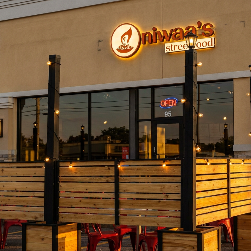 Niwaa's Street Food restaurant exterior with an outdoor patio area and string lights at sunset.